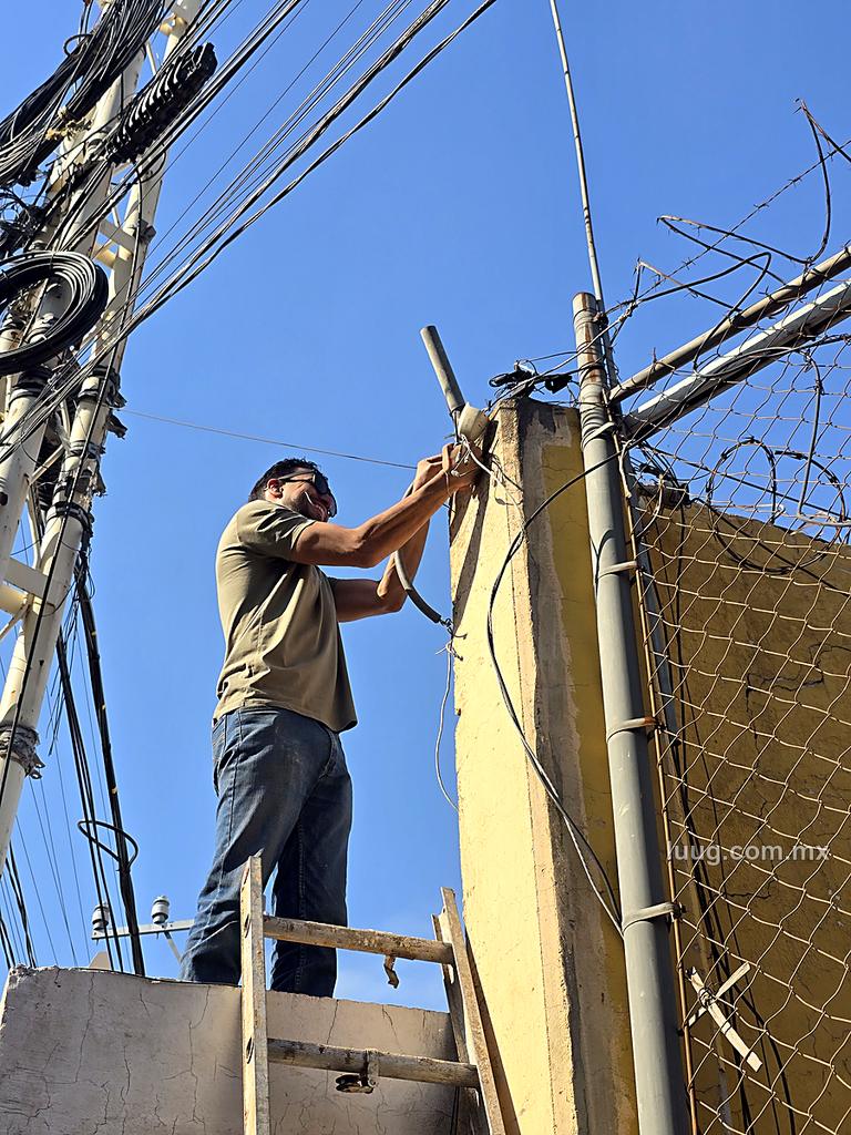 Técnico de Luug instalando una cámara sobre la barda